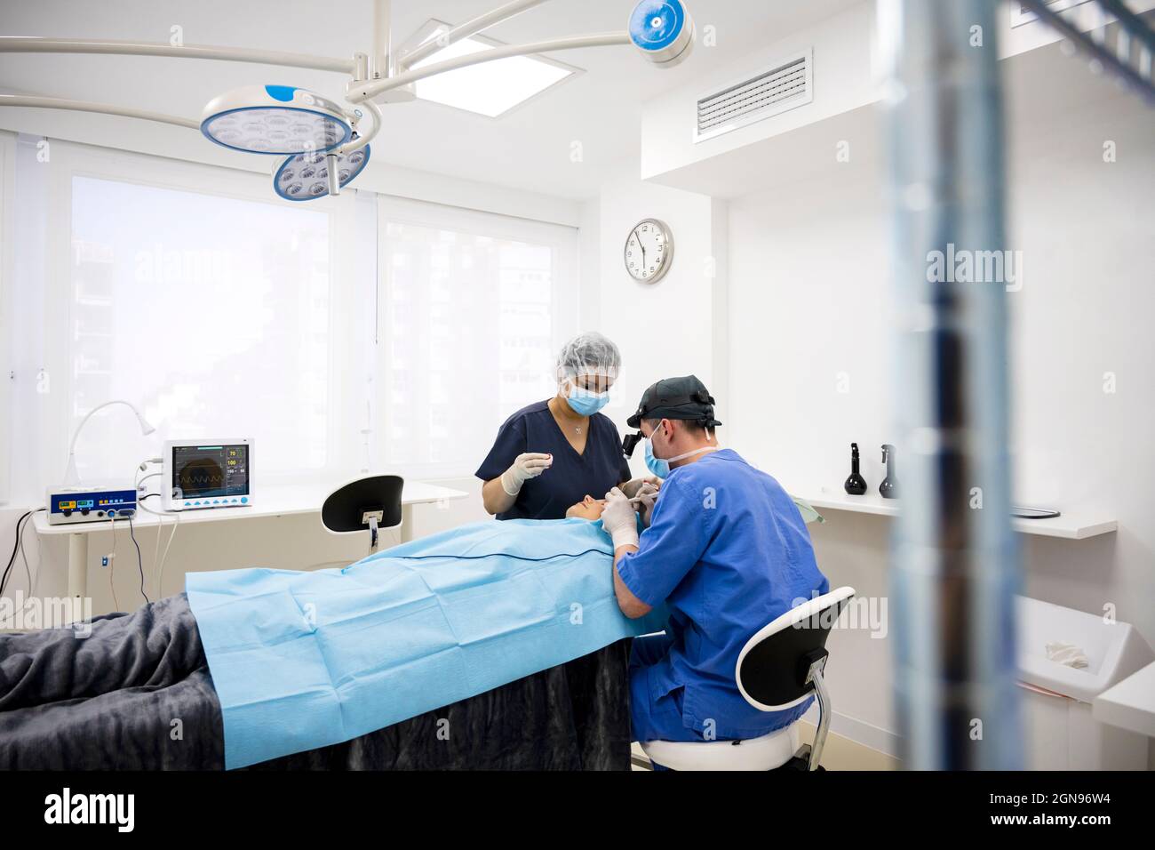 Der Chirurg näht das Augenlid nach einer plastischen Operation Stockfoto