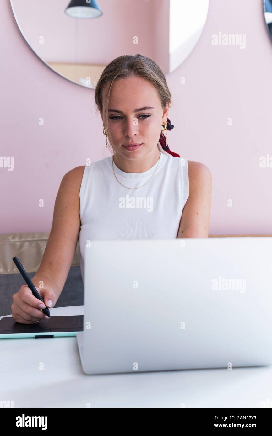 Junge weibliche Design-Profi mit Grafik-Tablet, während im Café sitzen Stockfoto Junge weibliche Design-Profi mit Grafik-Tablet, während im Café sitzen Stockfoto