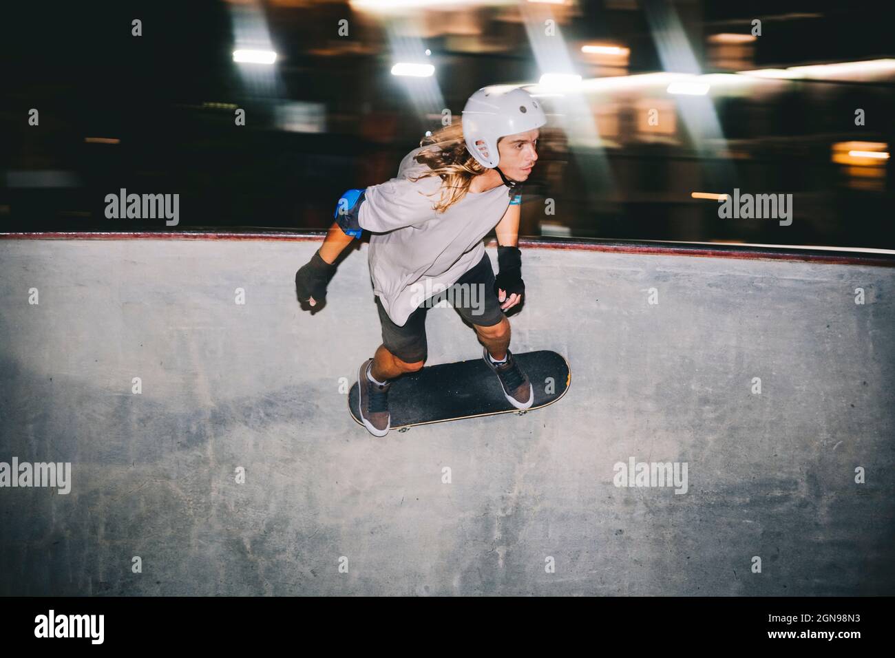 Mann mit Sporthelm Skateboarding auf Sportrampe Stockfoto