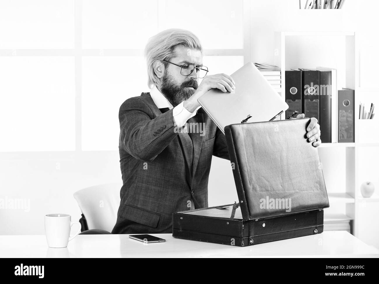 Finanzdirektor mit Koffer. Geschäftsattribute. Geschäftsführer des Unternehmens. Erfahrener Regisseur. Erwarteter kommerzieller Nutzen. Mann und Aktentasche Stockfoto