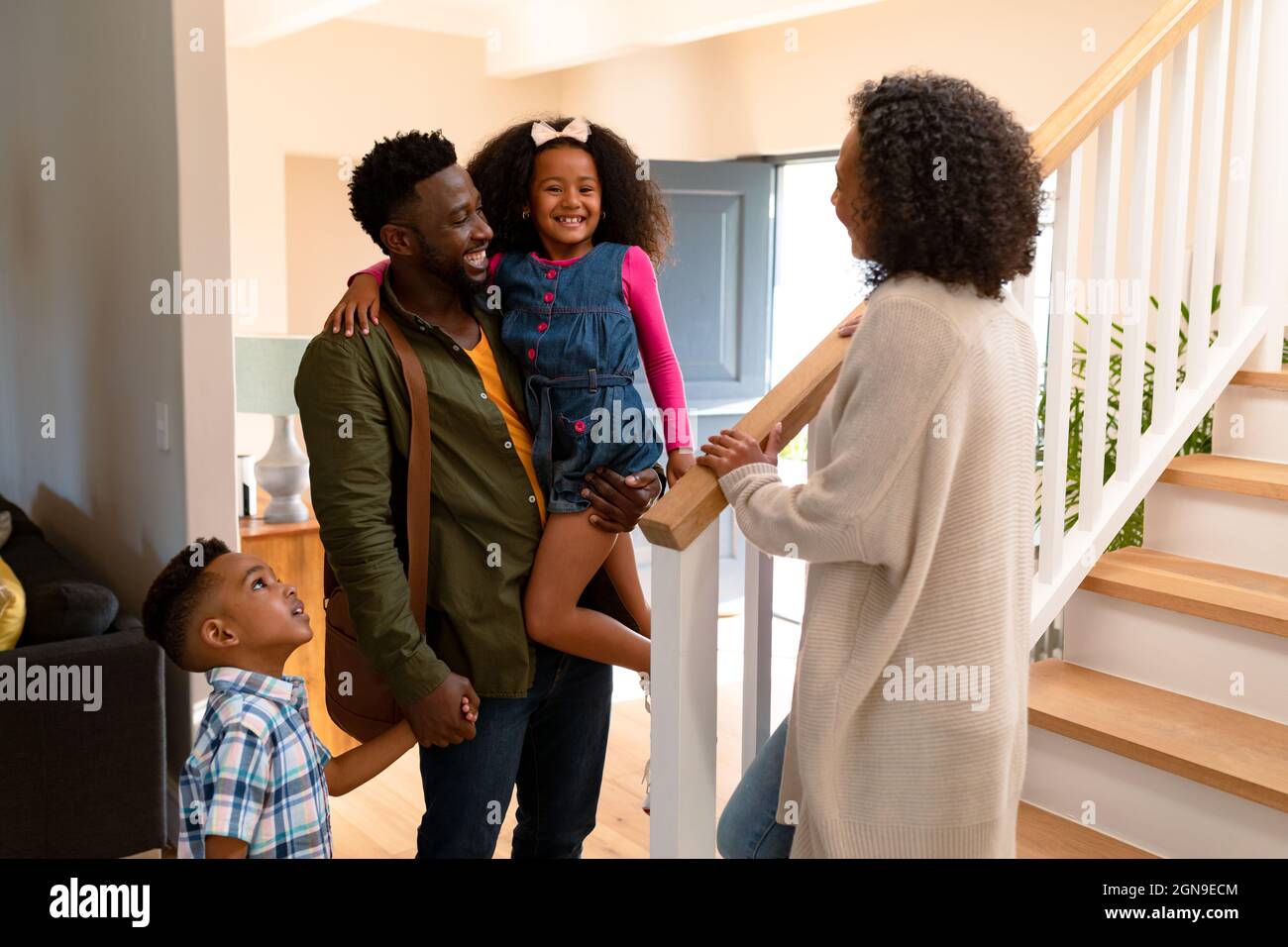 Glückliche afroamerikanische Familie, die Vater willkommen heißt, der nach Hause kommt Stockfoto Glückliche afroamerikanische Familie, die Vater willkommen heißt, der nach Hause kommt Stockfoto