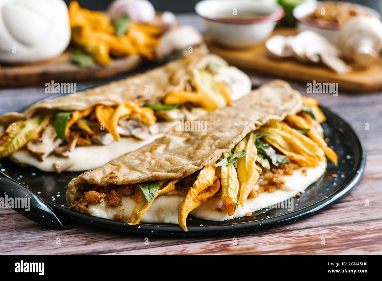 Traditionelle mexikanische Quesadillas mit Squashblüte, geschmolzenem oaxaca-Käse, Schweineschinde (chicharrón) und Pilzen in Mexiko-Stadt Stockfoto