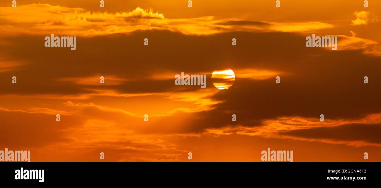 Telefoto von gelb-orange Sonnenuntergang Sonnenaufgang, Wolken, Himmel goldene Stunde Stockfoto