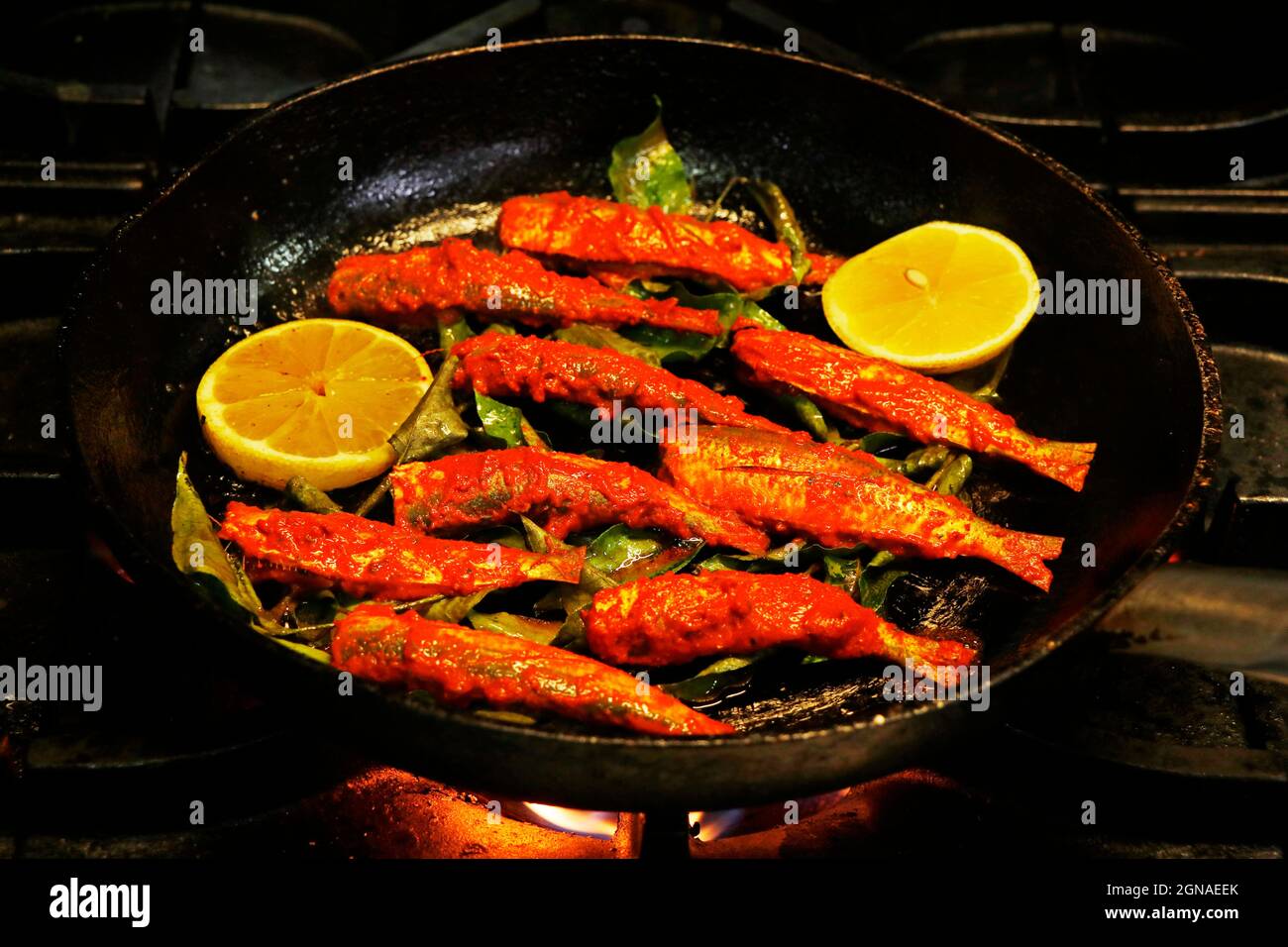 kerala-Stil masala marinierten Fisch braten, Sardinenfisch in einer Pfanne. Stockfoto