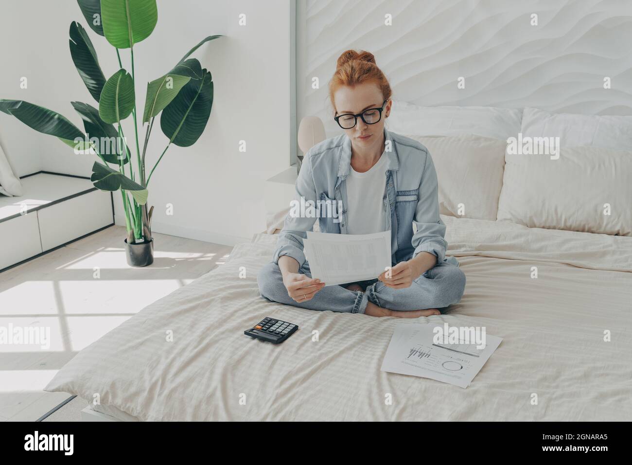 Gut aussehende Rothaarige Europäische Frau berechnet Ausgaben verwaltet Haushaltsbudget Stockfoto