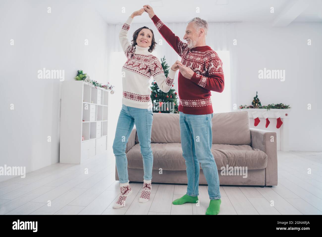 In voller Länge Foto von lustigen Paar ältere Dame Mann Tanz tragen  Pullover Jeans Socken zu Hause Stockfotografie - Alamy