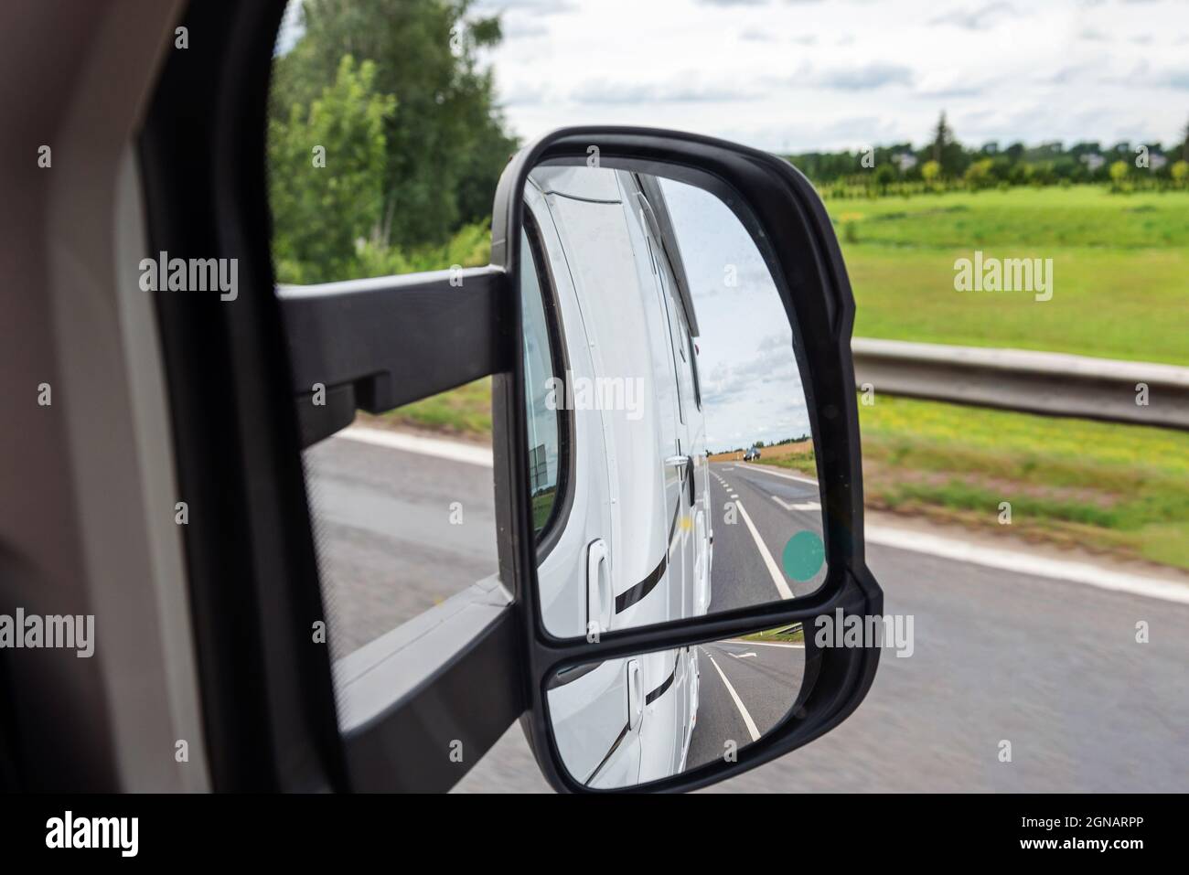 Blick auf die Straße vom Seitenspiegel. Anreise mit dem Auto Stockfoto