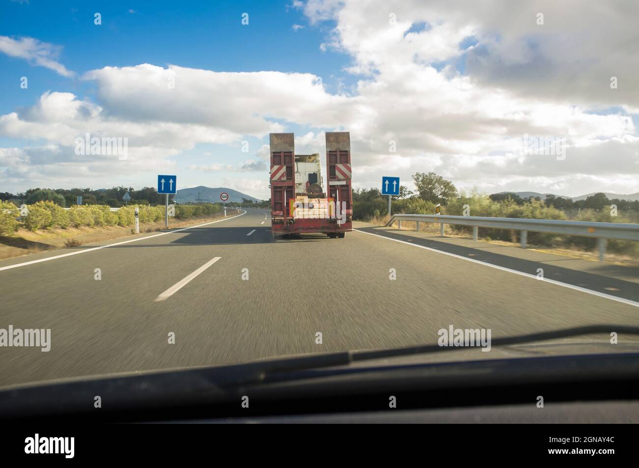 Schwerlast-Lkw mit gefalteter Plattform, die leer fährt. Blick von innen Stockfoto