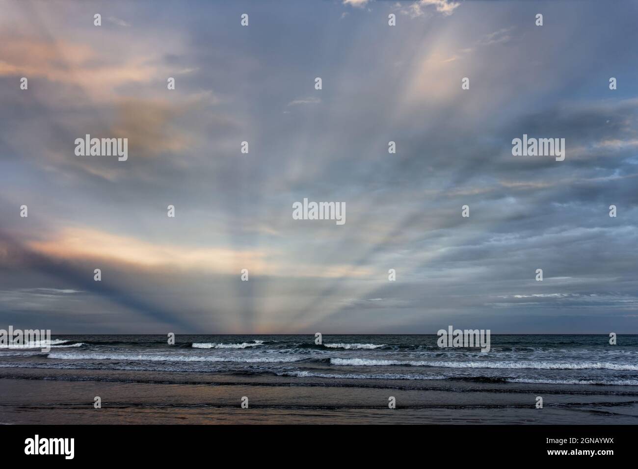 Lichtstrahlen kommen aus dem Osten, wenn die Sonne im Westen untergeht. Kuriose Phänomene am Woodend Beach, Südinsel, Neuseeland. Stockfoto