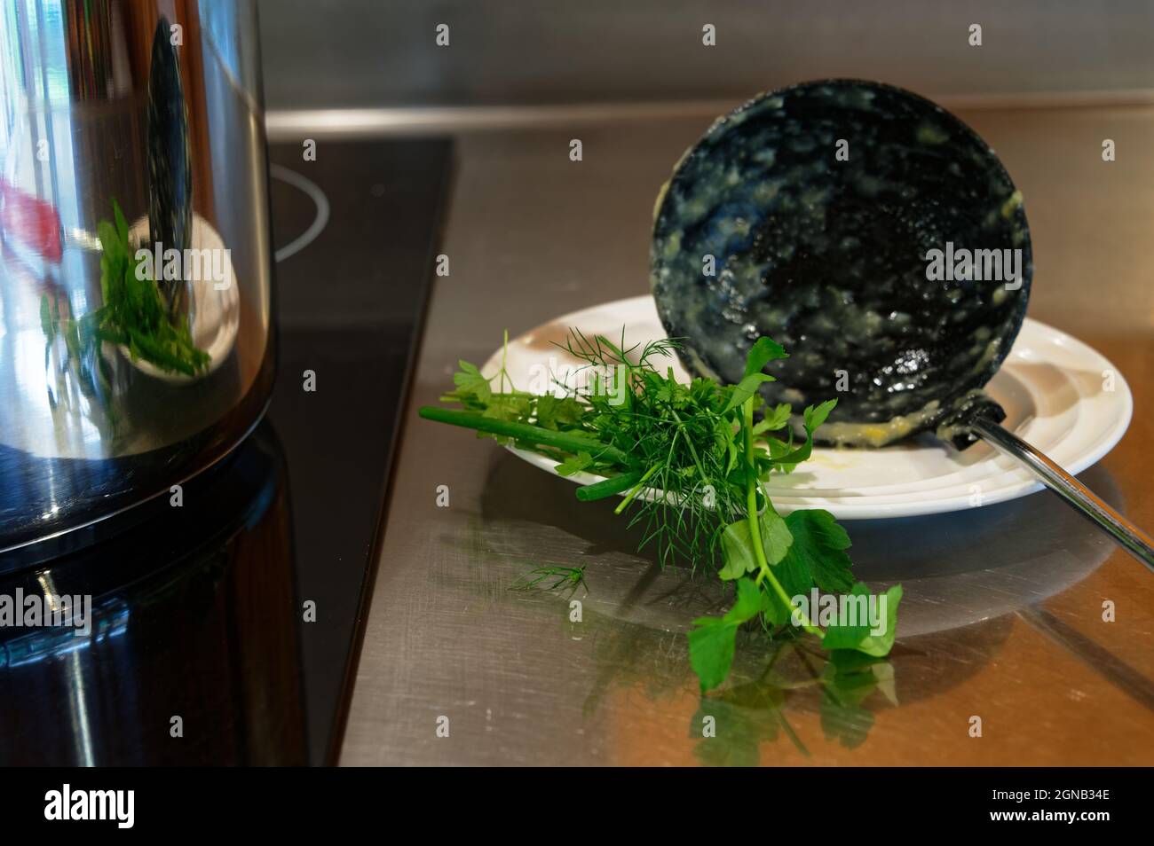 Die Suppe ist fast fertig zum Essen, mit frischen Kräutern, die darauf warten, hineinzukommen. Stockfoto