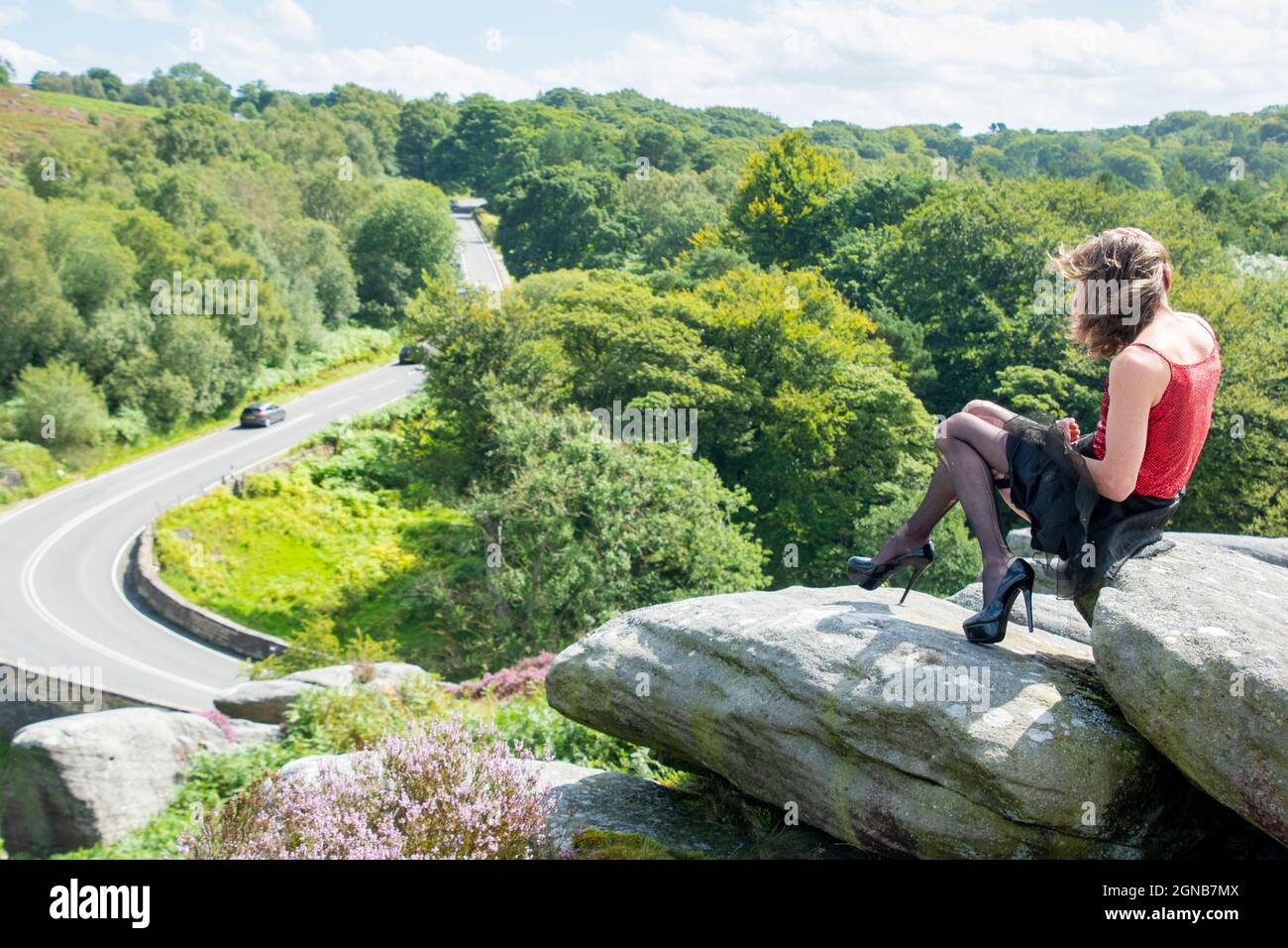 Derbyshire UK – 20. Aug 2020: Simon in Heels saß auf der Kröten-Mündung, einer ikonischen Felsformation mit Blick auf die A6187 Hathersage Road, Peak District Stockfoto