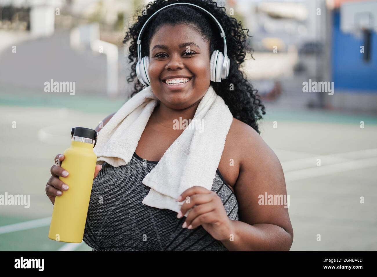 Sport kurvige schwarze Frau Musik hören mit Kopfhörern - Fokus auf Gesicht Stockfoto