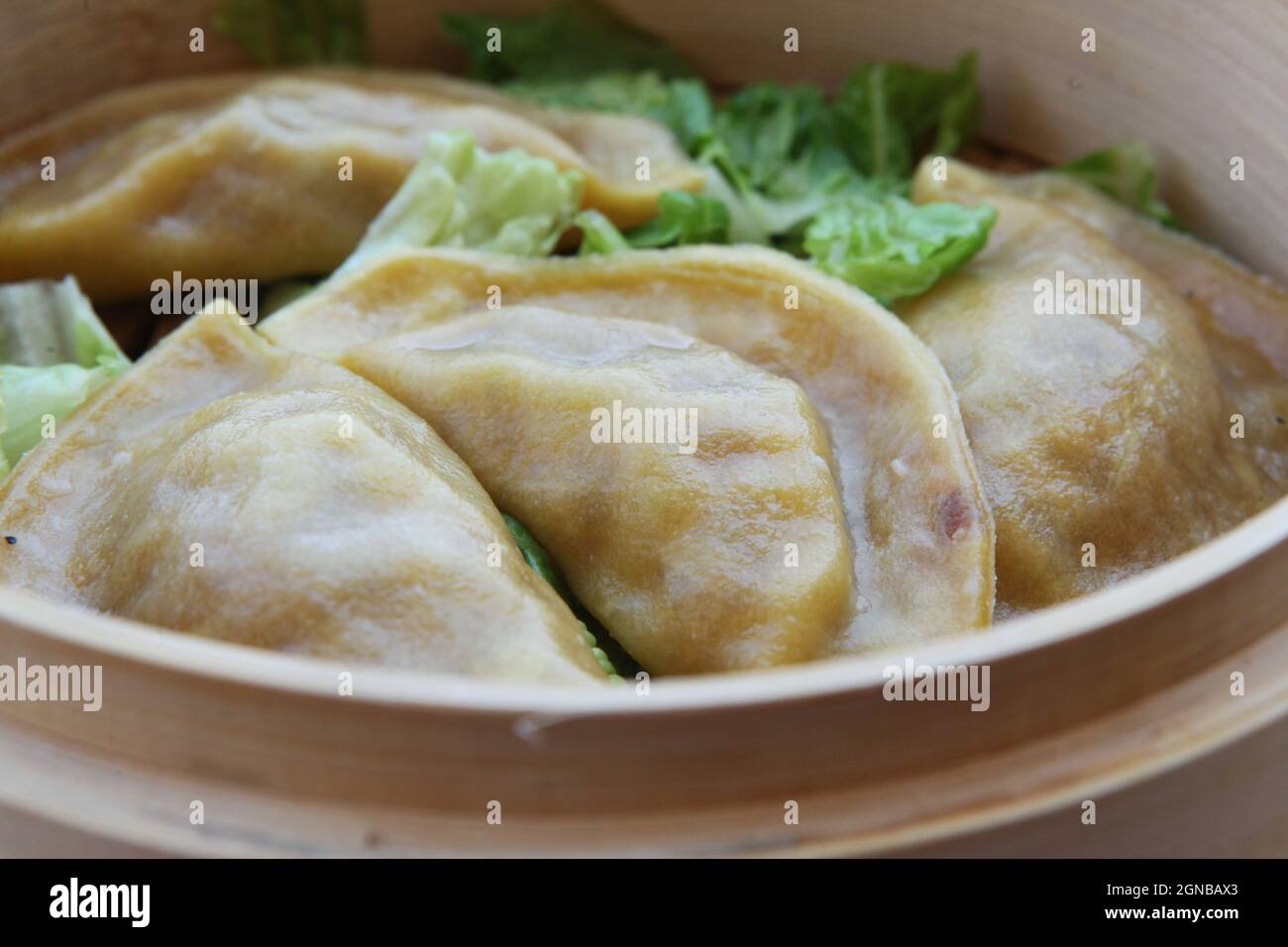 Gestreamte Gyoza (Jiaozi) in dampfenden Korb Bambus Stockfoto