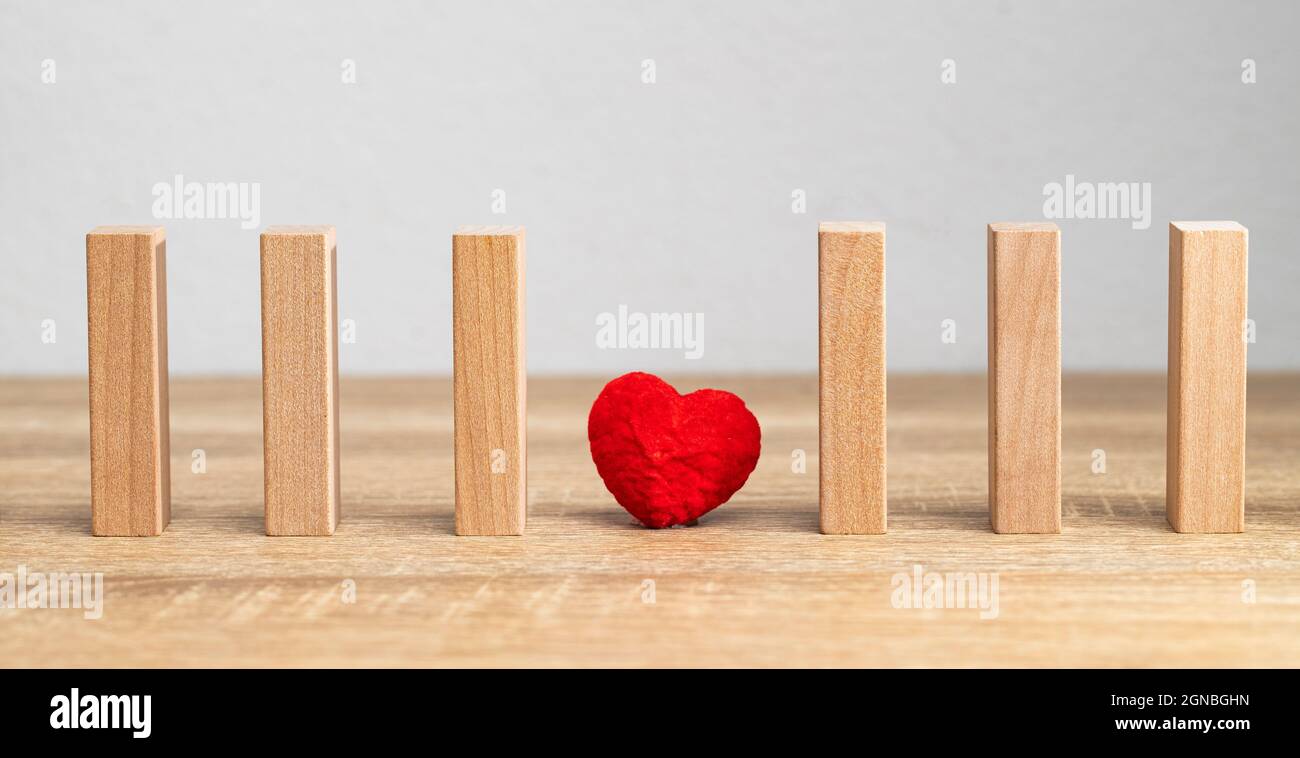 Ein rotes Herz ist die Bedeutung für die Liebe und den süßen Moment. Es ist zwischen dem hölzernen Jenga wie die Liebe ist einsam und Risiko Moment. Stockfoto