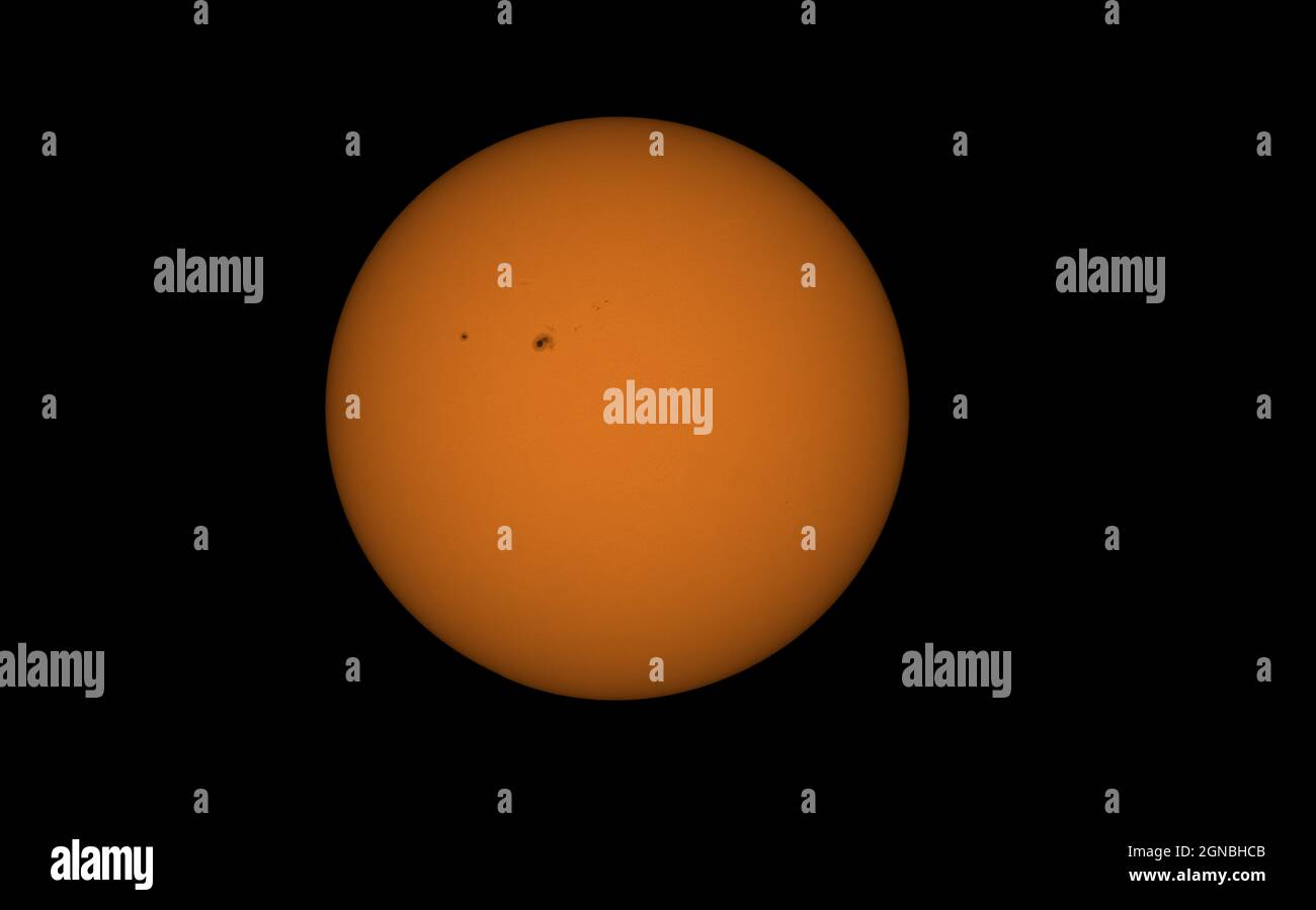 Die Sonnen- und Sonnenflecken mit einem brechenden Teleskop und einem Filter, um das Licht zu dämpfen Stockfoto