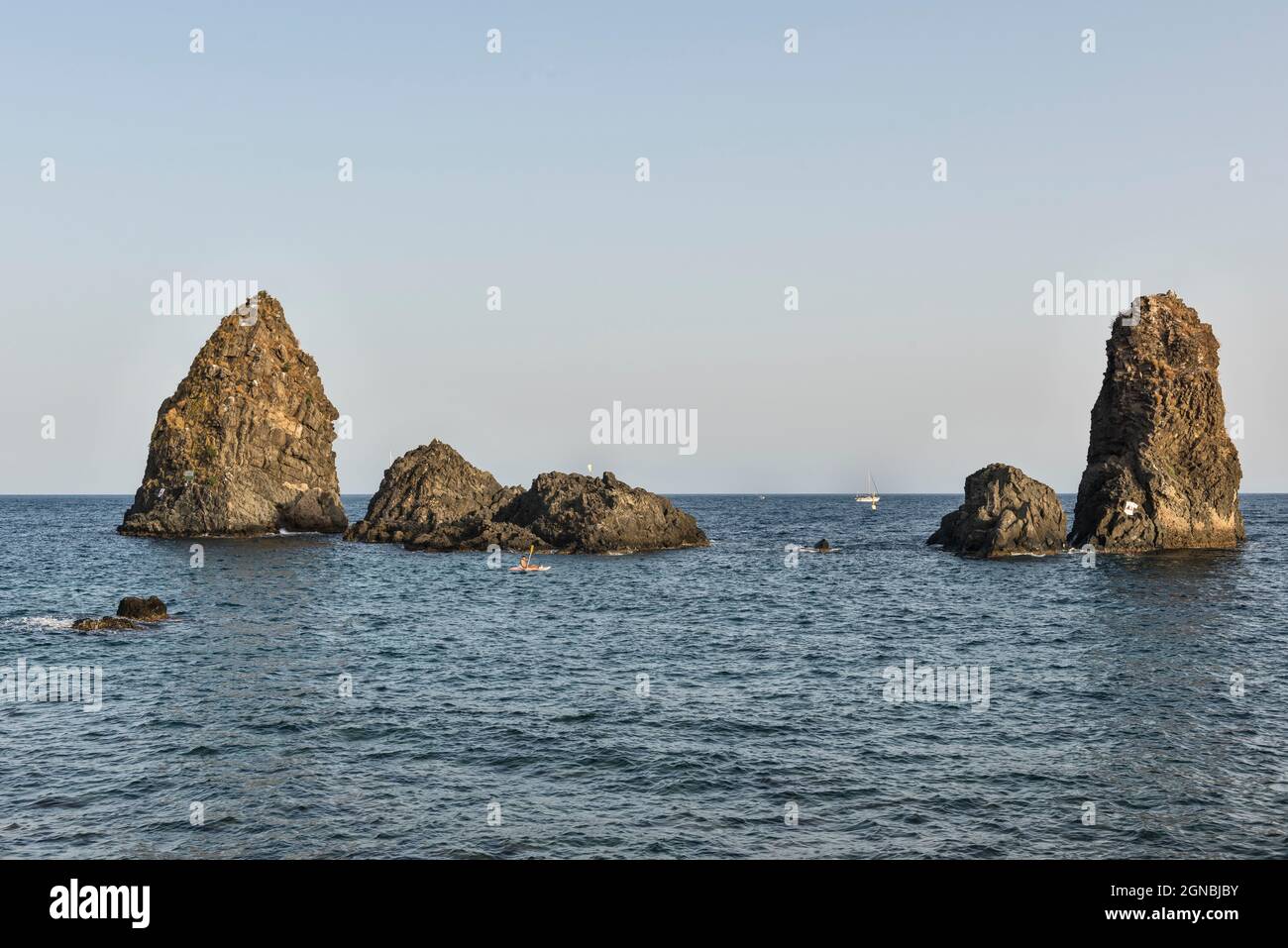 Die Faraglioni, eine Gruppe vulkanischer Basaltmeeres, stapeln sich vor Aci Trezza (Acitrezza), Sizilien, Italien. Auch bekannt als Isole Ciclopi (Zyklopen-Inseln) Stockfoto