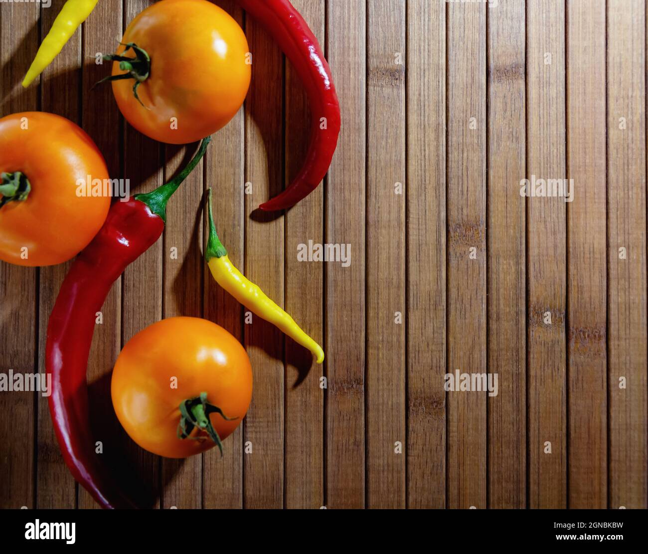 Gelbe Tomaten und rote Paprika liegen auf einem hölzernen Hintergrund, horizontales Bild. Hochwertige Fotos Stockfoto