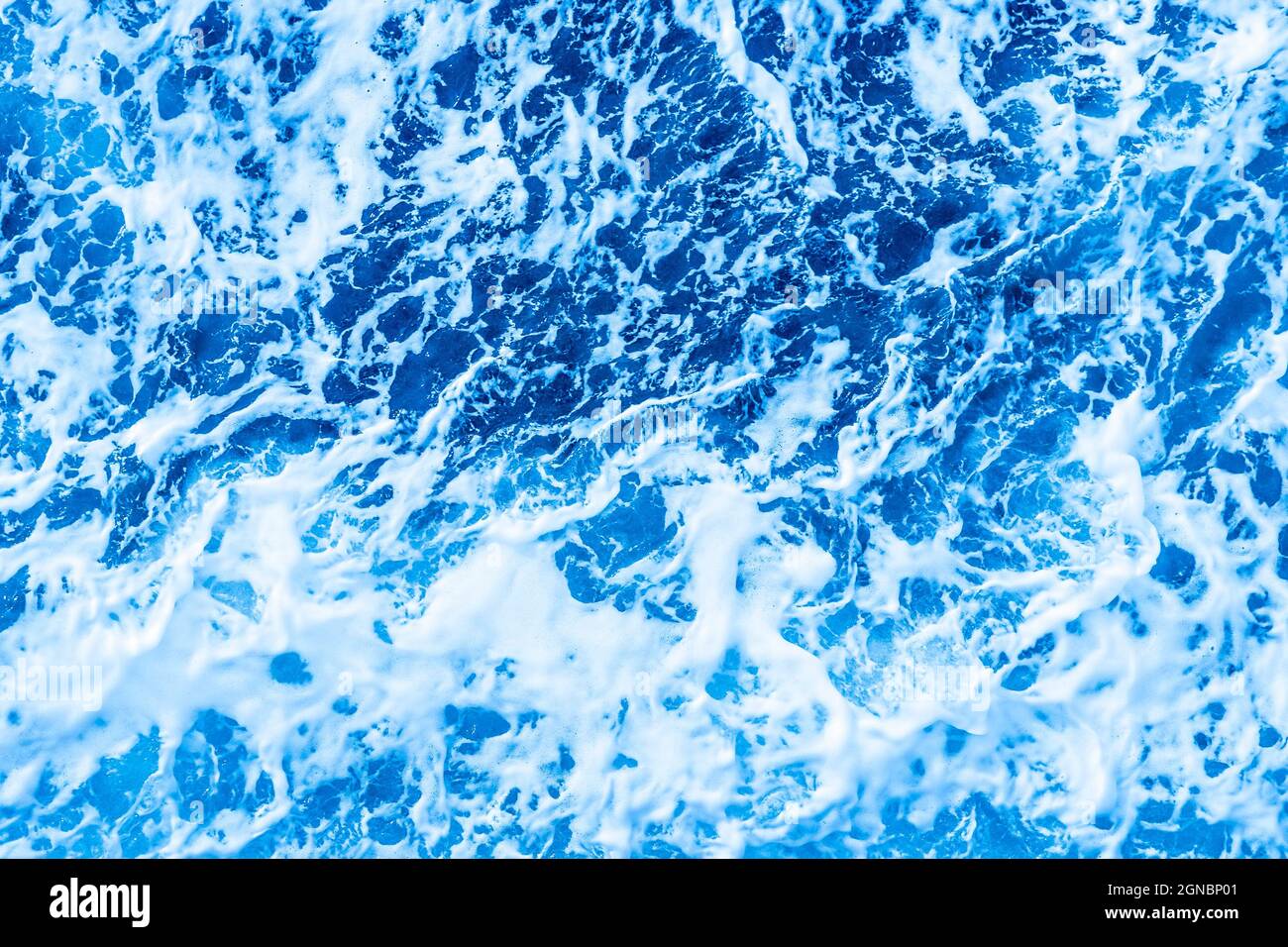 Luftbild Ozeanwasser blaue Oberfläche mit Schaum und Wellen. Stockfoto