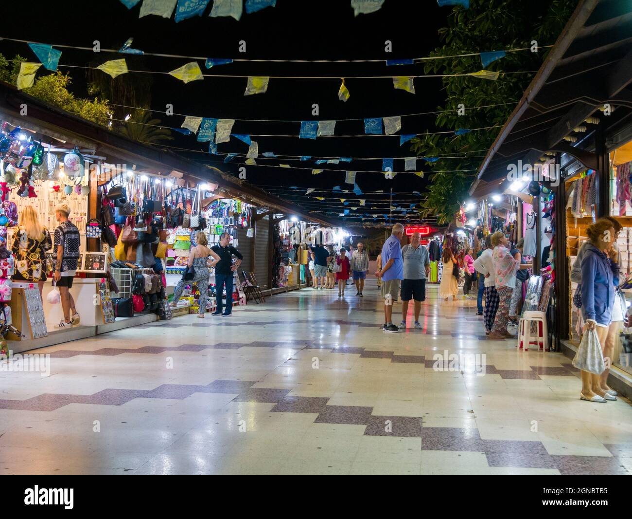 Leute, die nachts an den Marktständen an der Strandpromenade von Torrevieja an der Costa Blanca, Spanien, stöbern. Stockfoto