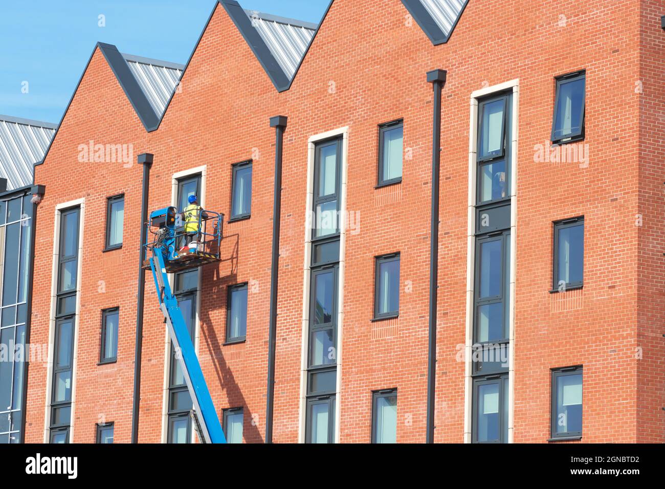 Ein Bauherr wendet den letzten Schliff an ein neues modulares Studentenwohnungsgebäude in Hereford für HAC und NMITE im September 2021 an Stockfoto