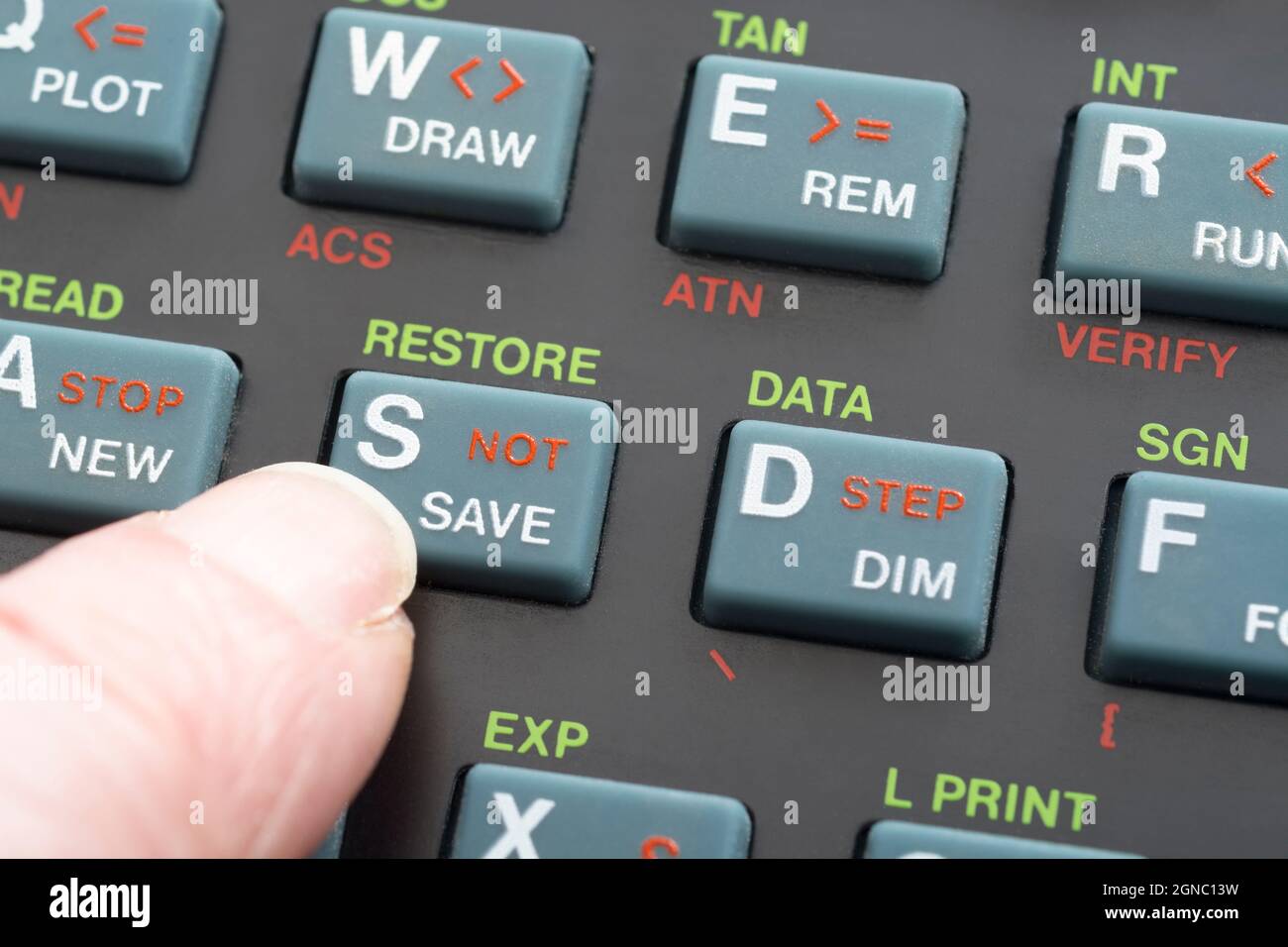 Nahaufnahme der Sinclair ZX Spectrum Tastatur. Mit dem Finger auf die Befehlstaste zum Speichern des Basisprogramms konzentrieren. Klassischer 8-Bit-Heimcomputer aus den 1980er Jahren (siehe Hinweise). Stockfoto