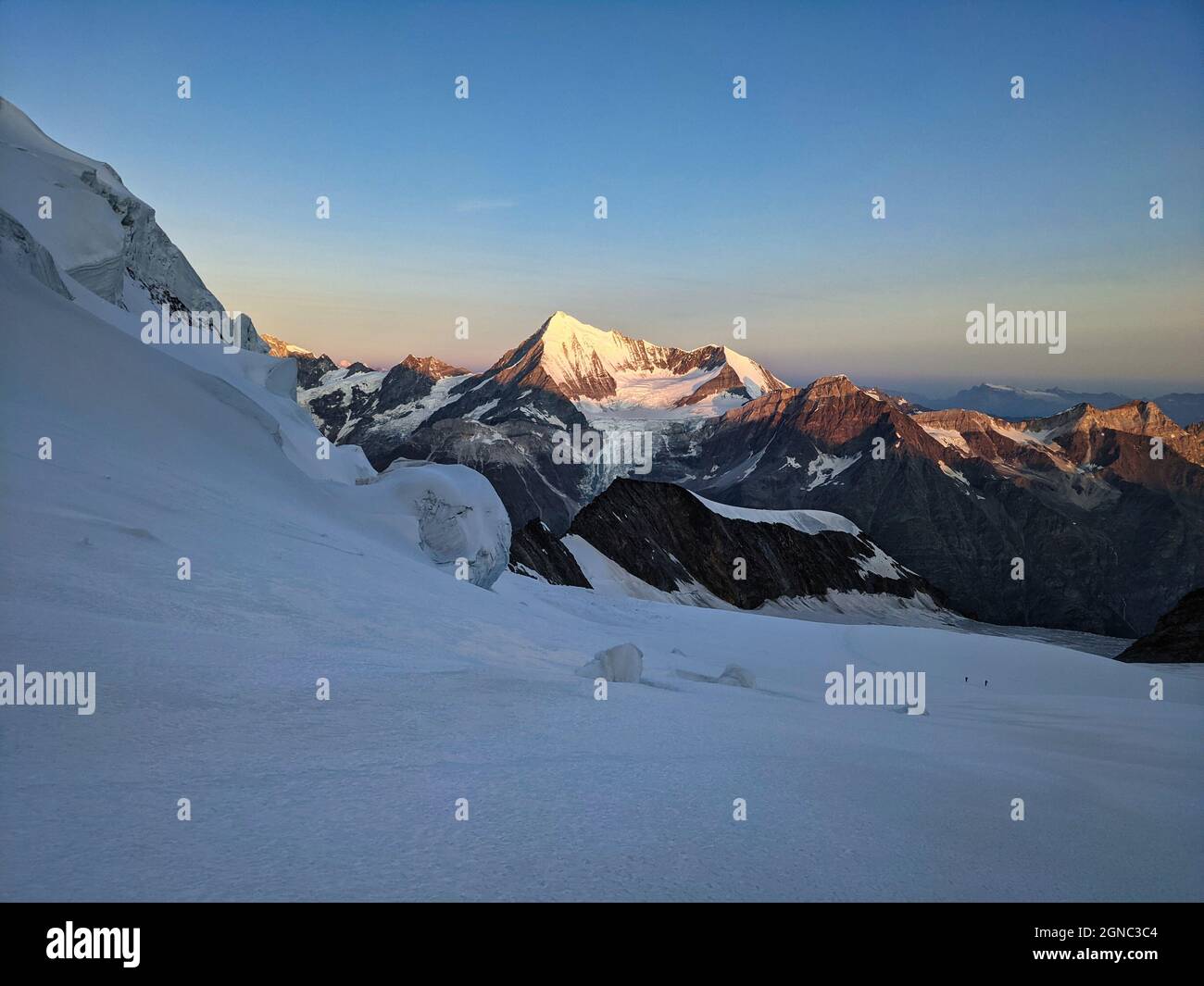 Bergsteigen auf dem höchsten Berg der Schweiz Dom 4545. Sonnenaufgang auf dem Gletscher mit Blick auf das Weisshorn. Stockfoto