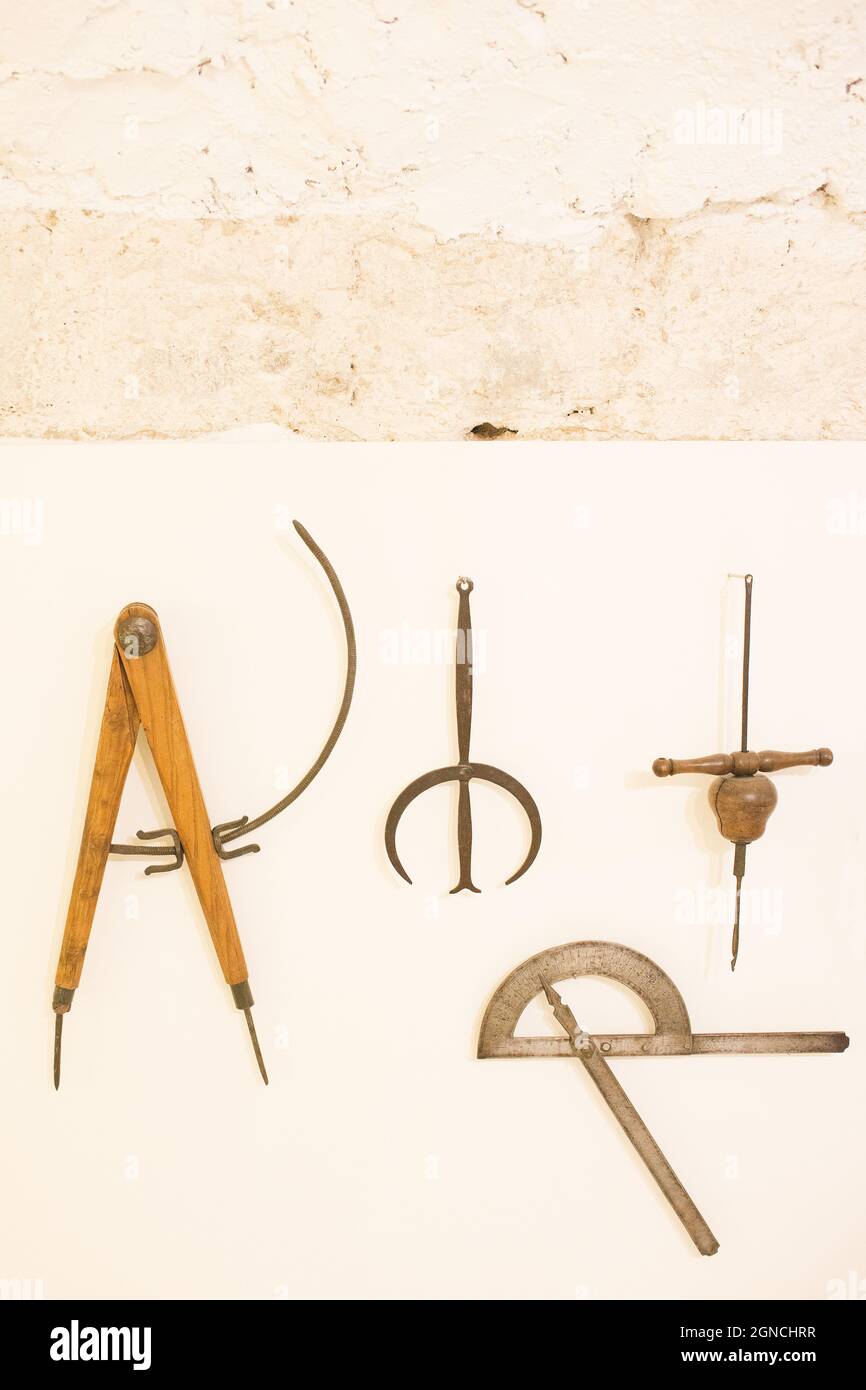 Alte hölzerne Werkzeuge zum Zeichnen, Messen und Bauen.Werkzeuge, die an einer Wand hängen. Museum in Teruel, Aragon, Spanien, Europa Stockfoto