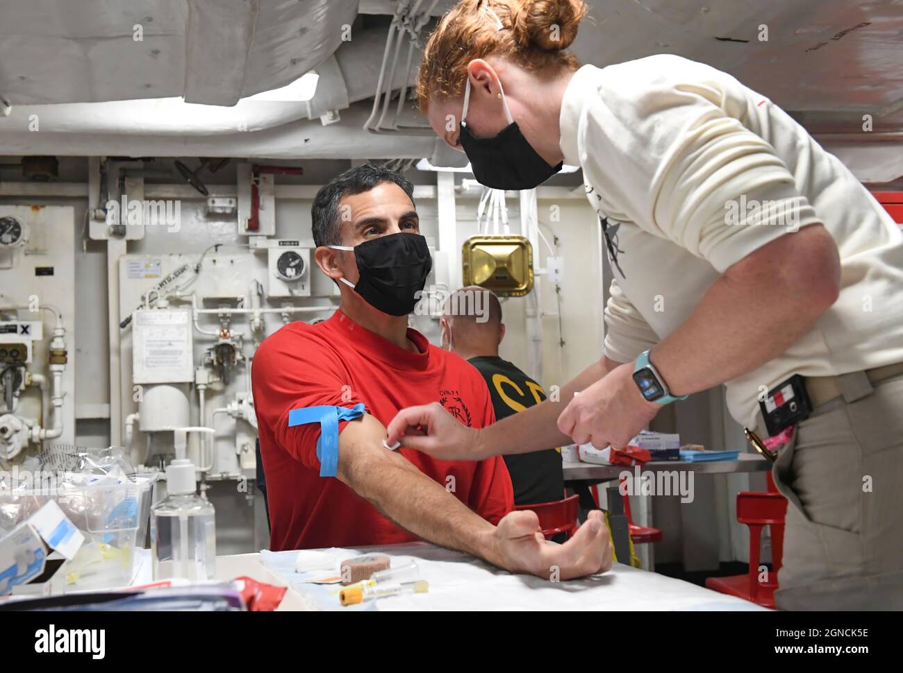 PHILIPPINISCHES MEER (19. Juni 2020) Capt. Carlos Sardiello, links, Kommandant des Flugzeugträgers USS Theodore Roosevelt (CVN 71), spricht mit LT. Jessica Oliver, der Krankenschwester des Schiffes, bevor er Blut zum Testen auf COVID-19-Antikörper gab, 19. Juni 2020. Die Theodore Roosevelt Carrier Strike Group ist im Indo-Pazifik-Raum im Einsatz. (USA Navy Foto von Mass Communication Specialist 2nd Class Robyn B. Melvin/veröffentlicht)200619-N-FP690-1051 Stockfoto