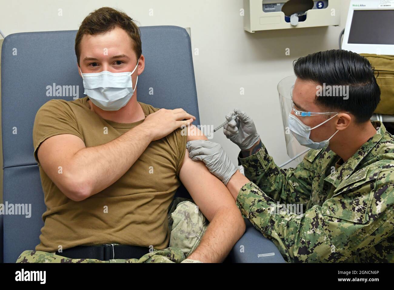 PEARL HARBOR (Dez. 16, 2020) Hospital Corpsman 3rd Class David Tuil, der Abteilung für Präventivmedizin der Naval Health Clinic Hawaii (NHCH) zugewiesen, verwaltet einen der ersten Pfizer-BioNTech COVID-19-Impfstoffe am NHCH an Hospital Corpsman 3rd Class Gage Finn, ein Mitglied des COVID-19 Expeditionary Testing Teams am NHCH, 16. Dezember 2020. NHCH hat zunächst eine begrenzte Menge an COVID-19-Impfstoffen für medizinisches Personal vor Ort und Notdienste erhalten. NHCH verfolgt den schrittweisen, standardisierten und koordinierten Ansatz des Verteidigungsministeriums zur Verabreichung von COVID-19 va Stockfoto