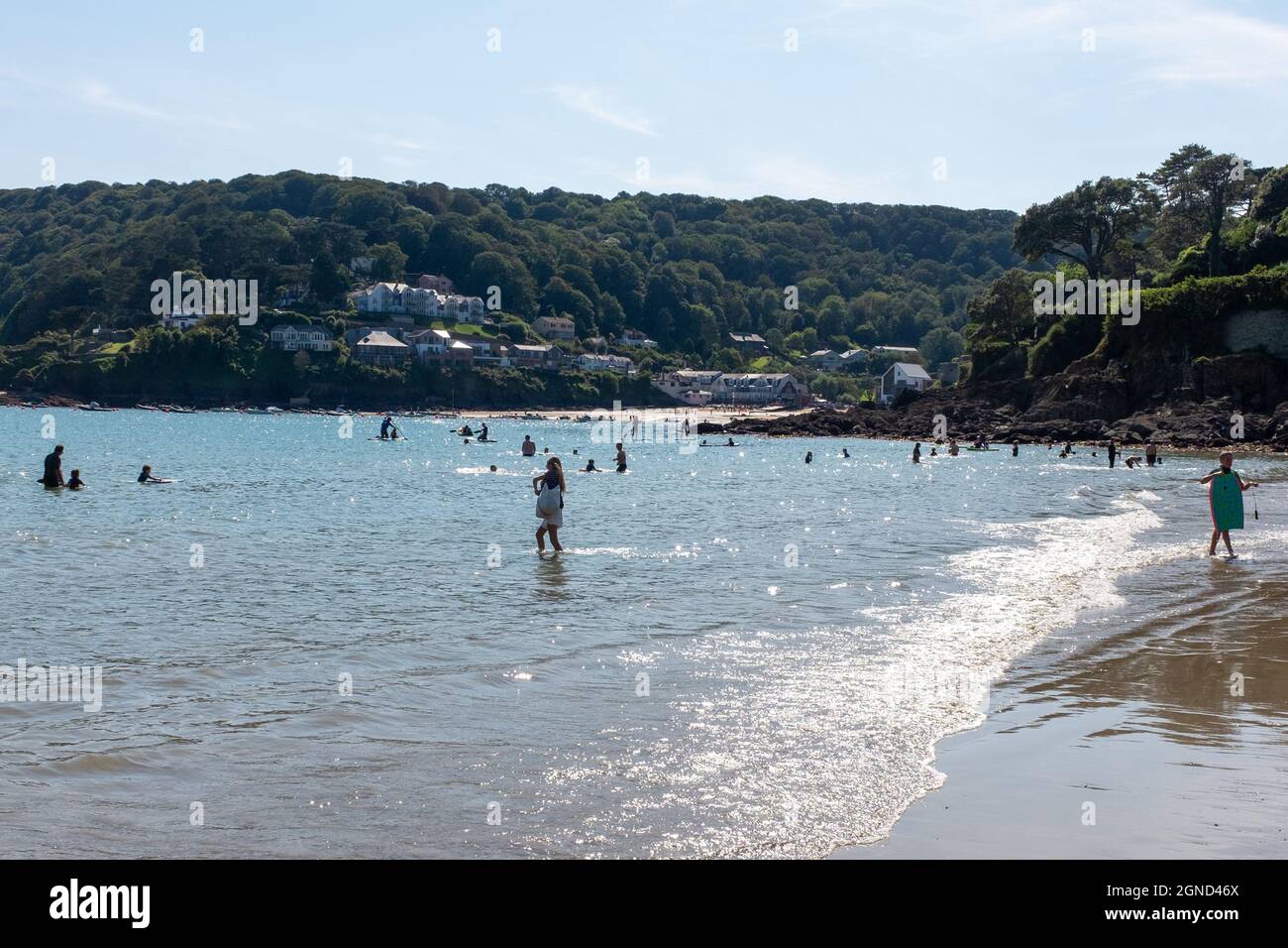 Ein Augusttag auf North Sands, Salcombe, South Hams, Devon, zeigt South Sands in der Ferne mit vielen Wassersportarten und Menschen, die Spaß haben. Stockfoto