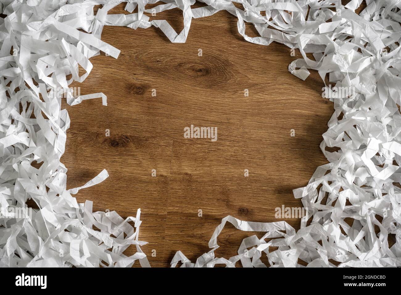 Rahmen aus geschreddertem Papier auf Holztisch für den Hintergrund, Draufsicht auf weißen Papierstreifen Haufen. Flach legen mit Konfetti und Kopierer Platz für Text. Konzept o Stockfoto