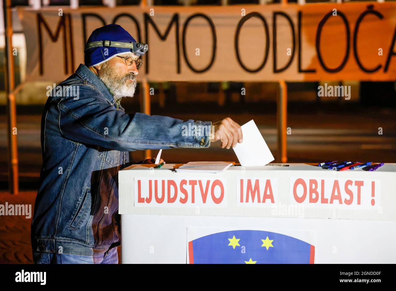 Ljubljana, Slowenien. September 2021. Ein Protestler wählt bei einer Scheinwahl während des regierungsfeindlichen Protests in Ljubljana seine Stimme. Die regierungsfeindlichen Proteste am Freitag, die seit mehr als eineinhalb Jahren stattfinden, setzten sich am Freitag fort und verlange klare Forderungen nach den bevorstehenden Wahlen, um die Herrschaft der Korruption und des Kapitals im Land zu beenden und eine gesunde Zukunft für die Umwelt zu schaffen. Kredit: SOPA Images Limited/Alamy Live Nachrichten Stockfoto