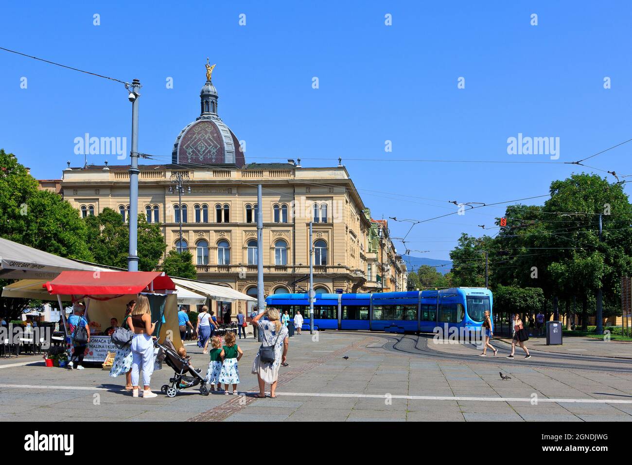 Eine blaue Straßenbahn, die am Starcevicev Dom (ehemalige Residenz der kroatischen Politikerin und Schriftstellerin Ante Starcevic (1823-1896) in Zagreb, Kroatien, vorbeifährt Stockfoto