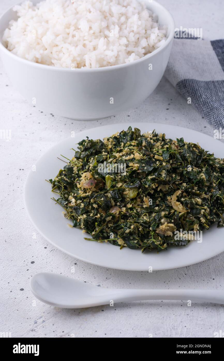 moringa oder Drumstick Laub Gericht, gemischt mit geriebener Kokosnuss und mit Öl, gesunde vegetarische Gericht auf einem Teller mit einem Löffel und ein Tuch Reis in temperiert Stockfoto