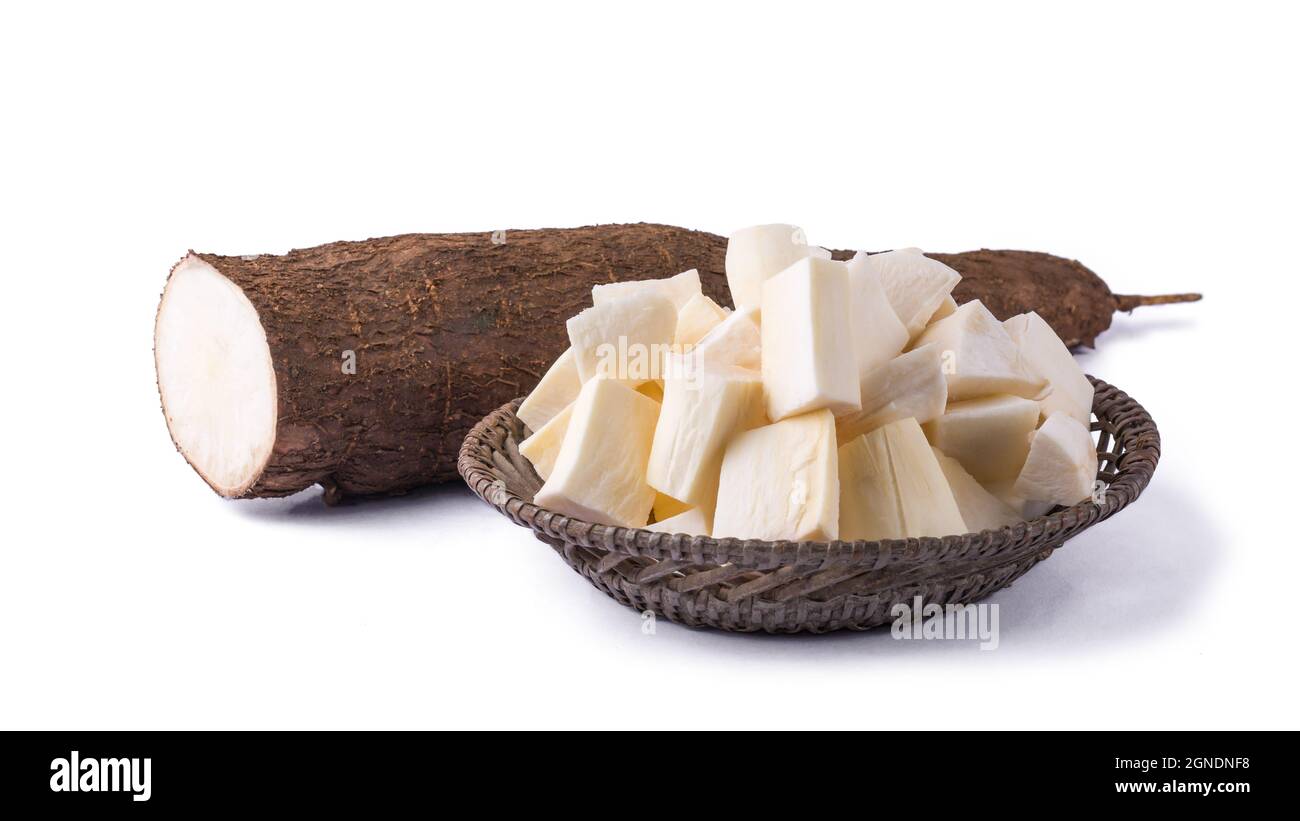 Cassava oder Manihot, auch bekannt als Manioc, Yuca oder Brazillian Pfeilwurzel, Wurzelgemüse in Stücke geschnitten, fertig zum Kochen mit einer halbgeschnittenen Wurzel, auf dem Whit Stockfoto