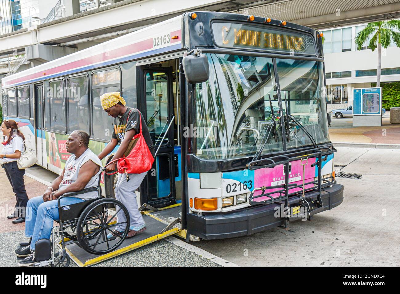 Miami Florida, Omni Busbahnhof Metrobus-Bushaltestelle, elektrischer Rollstuhl für Behinderte, schwarzer Mann, Frau, Paar mit ADA-Zugang Rampenboarding Stockfoto