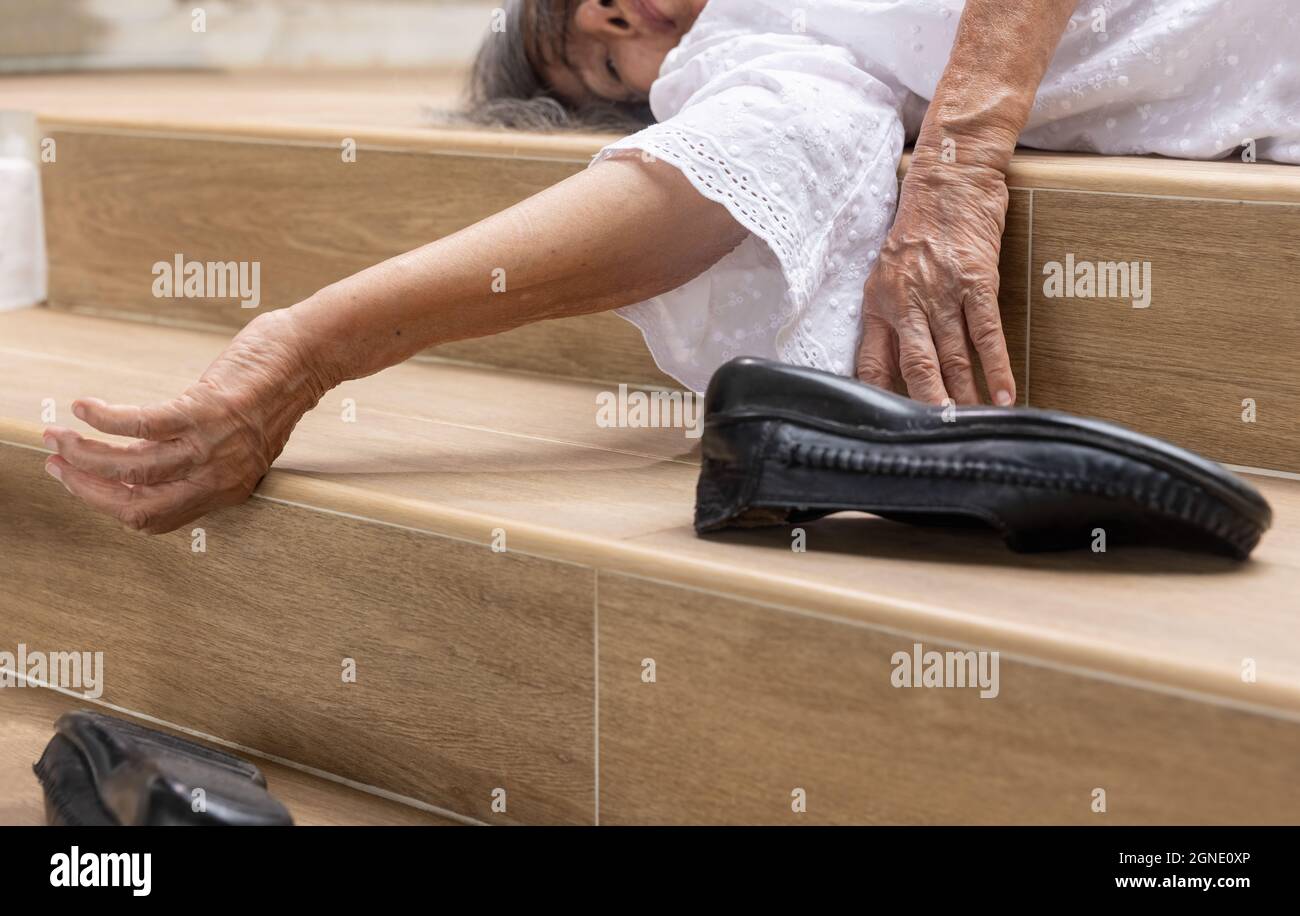 Ältere Frau, die auf die Treppe herunterfällt Stockfoto