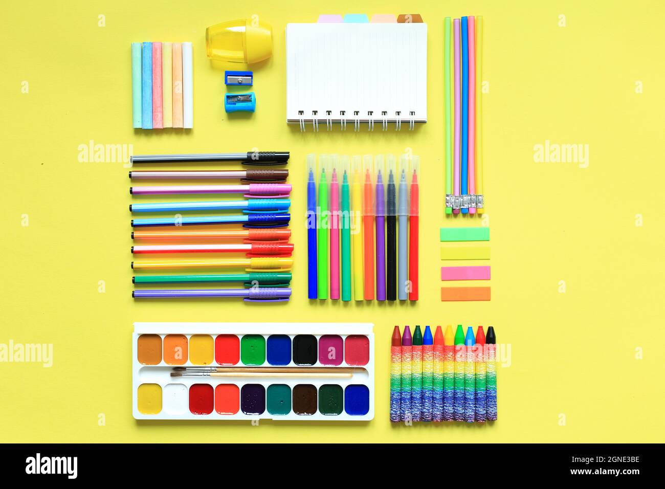 Malzubehör auf farbigem Hintergrund. Set der ersten Grader auf gelbem Hintergrund. Büromaterial in einem Layout auf einem gelben Papierhintergrund. Flaches Layout Stockfoto