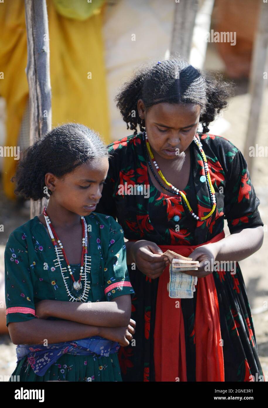 Eine Oromo-Frau zählt ihr Geld auf dem Wochenmarkt in Bati, Äthiopien. Stockfoto