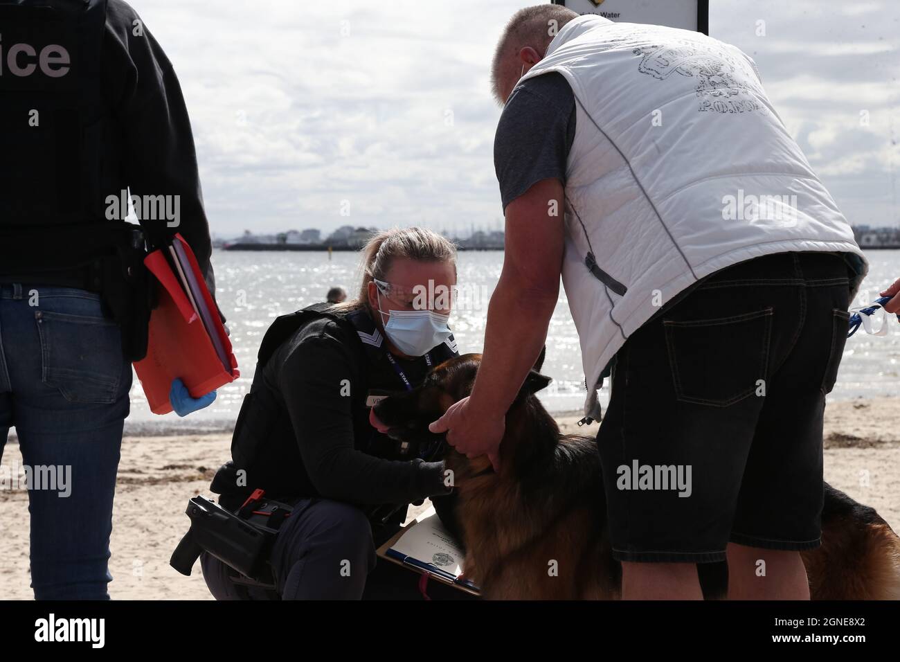 Melbourne, Australien, 25. September 2021. Ein Polizeibeamter begrüßt einen der lokalen Hunde während der „Millions March for Freedom“-Kundgebung in St. Kilda Beach. Melbourne erduldet einen weiteren Tag voller Proteste und Chaos über die umstrittene Regierung von Premier Daniel Andrews und die Reaktion auf Pandemiefälle, einschließlich Sperrungen und obligatorischer Impfungen. Kredit: Dave Hewison/Speed Media/Alamy Live Nachrichten Stockfoto