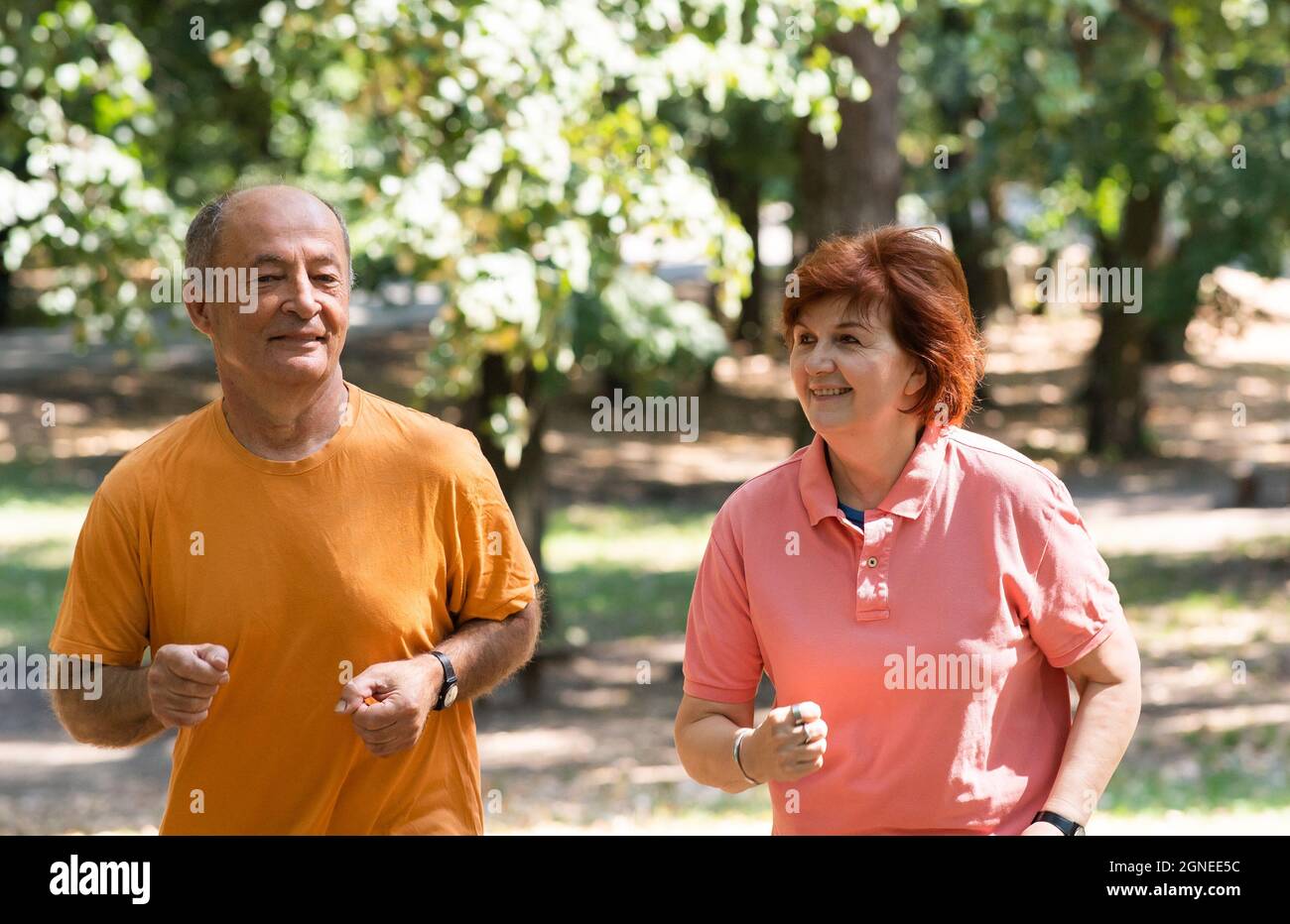 Glückliches Seniorenpaar, das im Park zusammenläuft Stockfoto