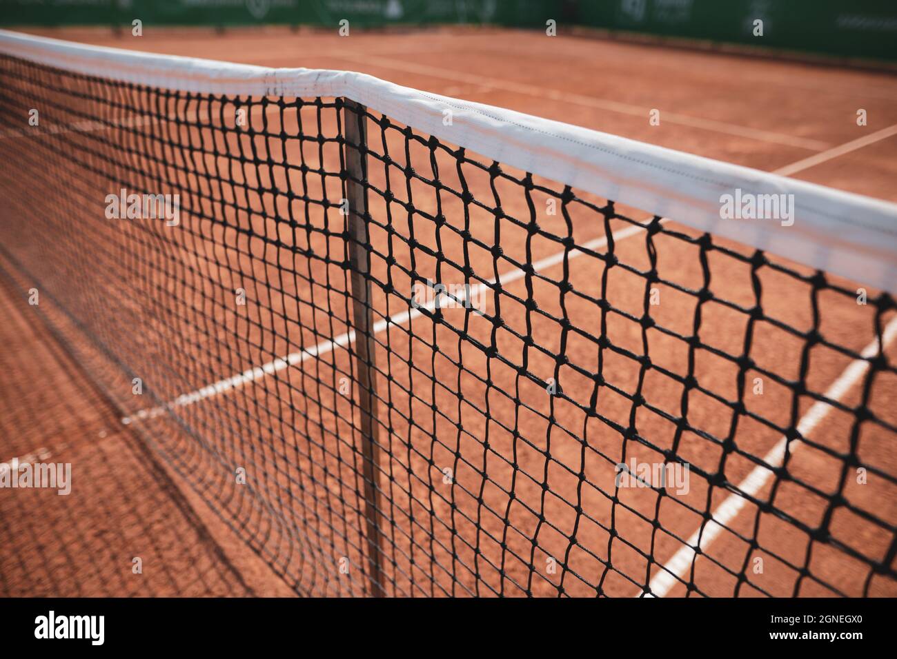 Bild mit geringer Schärfentiefe (selektiver Fokus) mit dem Netz eines Sandtennisplatzes. Stockfoto