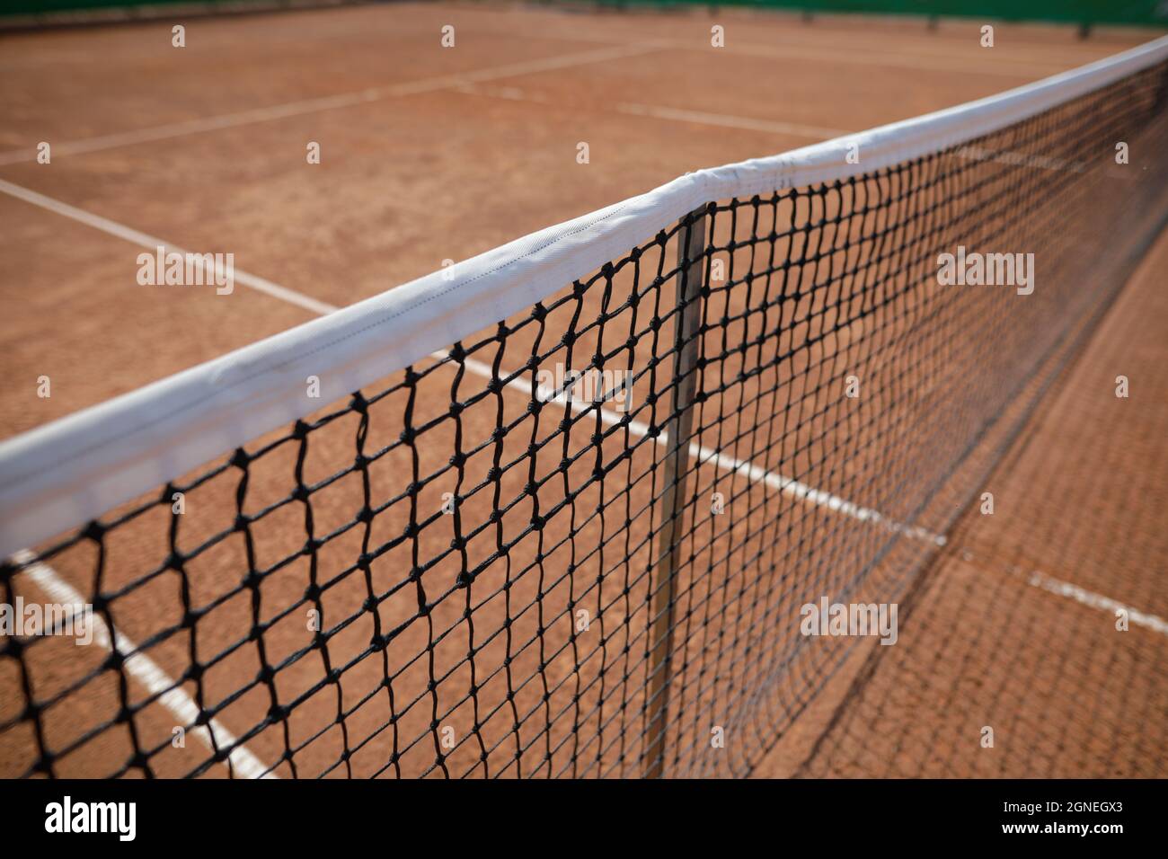 Bild mit geringer Schärfentiefe (selektiver Fokus) mit dem Netz eines Sandtennisplatzes. Stockfoto