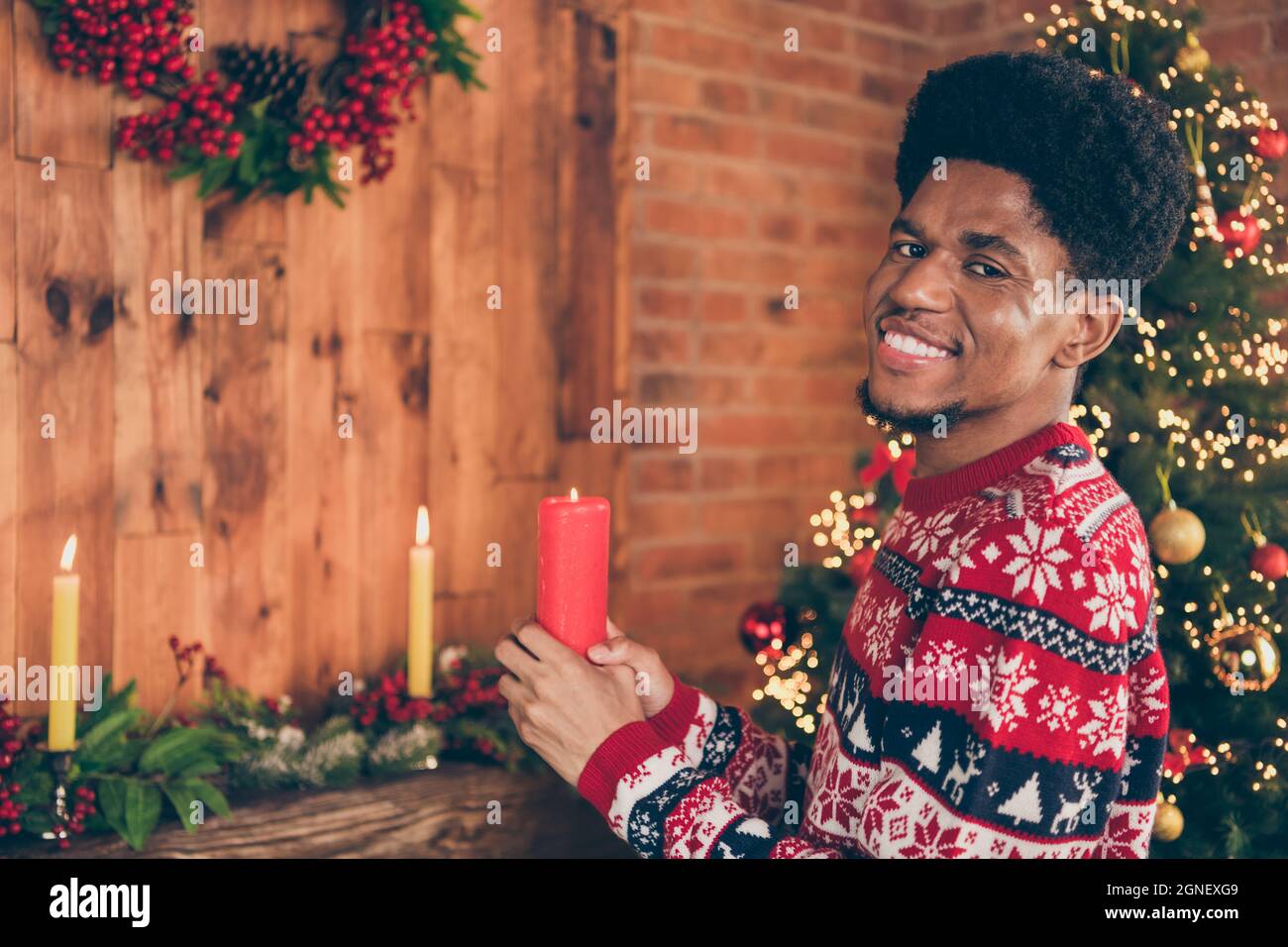 Foto Porträt Mann halten Kerze Dekoration apartmant vor Weihnachten lächelnd tragen Pullover mit Ornament Stockfoto