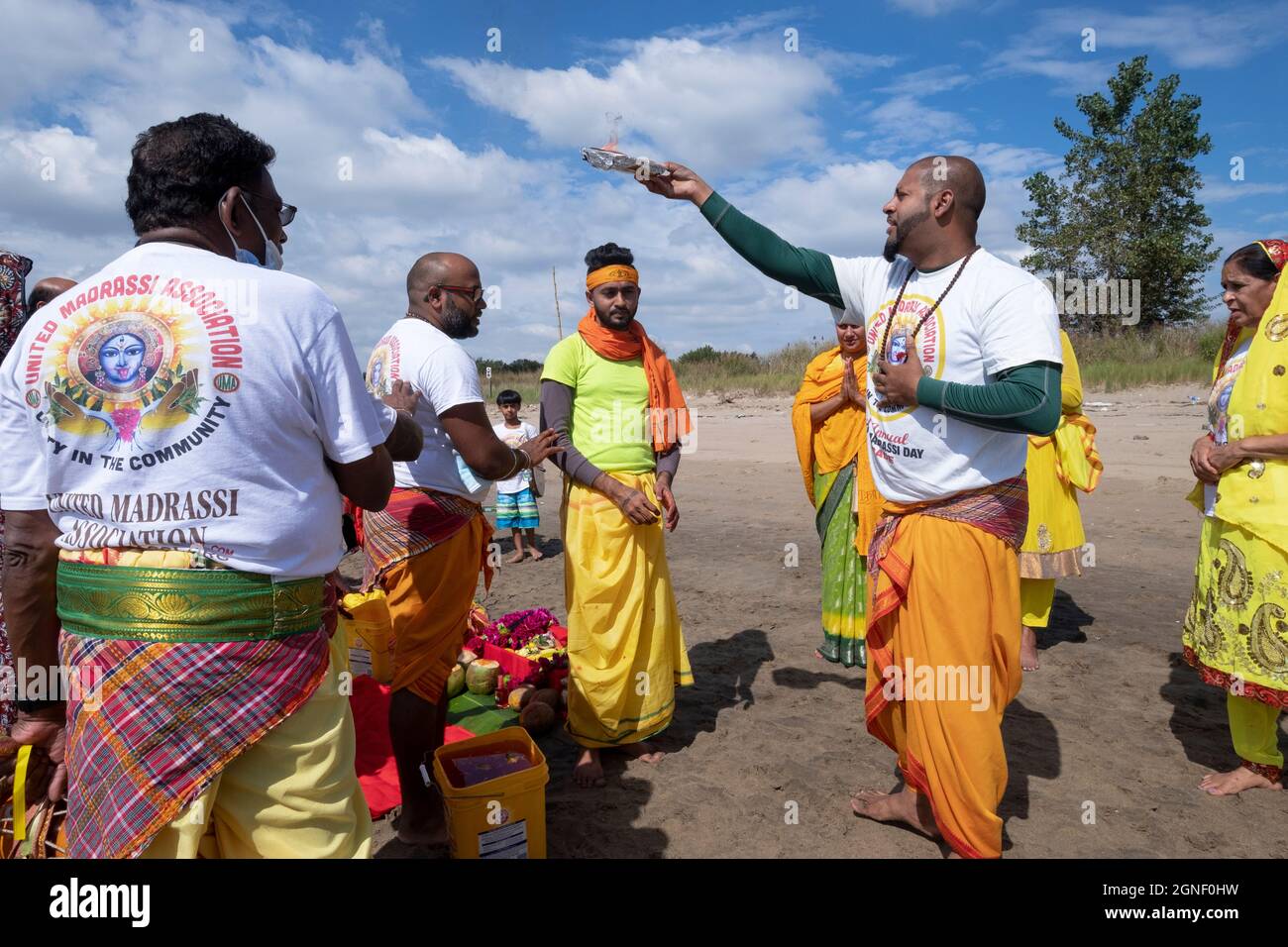 Fromme Hindus führen das Arti-Ritual der schwingenden Flammen bei einem Ganga- und Kateri-Amma Poosai-Gottesdienst in Jamaica Bay in Queens, New York City, durch. Stockfoto