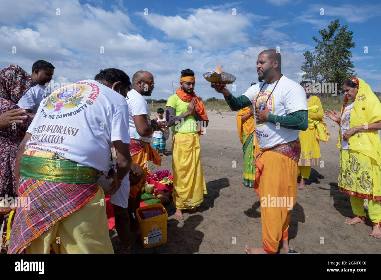 Fromme Hindus führen das Arti-Ritual der schwingenden Flammen bei einem Ganga- und Kateri-Amma Poosai-Gottesdienst in Jamaica Bay in Queens, New York City, durch. Stockfoto