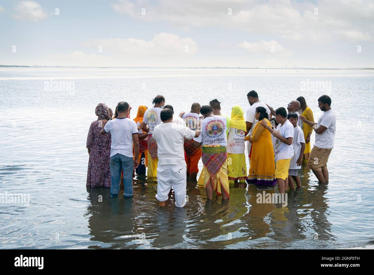 Hinduistisch-amerikanische Männer und Frauen verehren Rituale bei einem Ganga- und Kateri-Amma Poosai-Gottesdienst in Jamaica Bay in Queens, New York City. Stockfoto