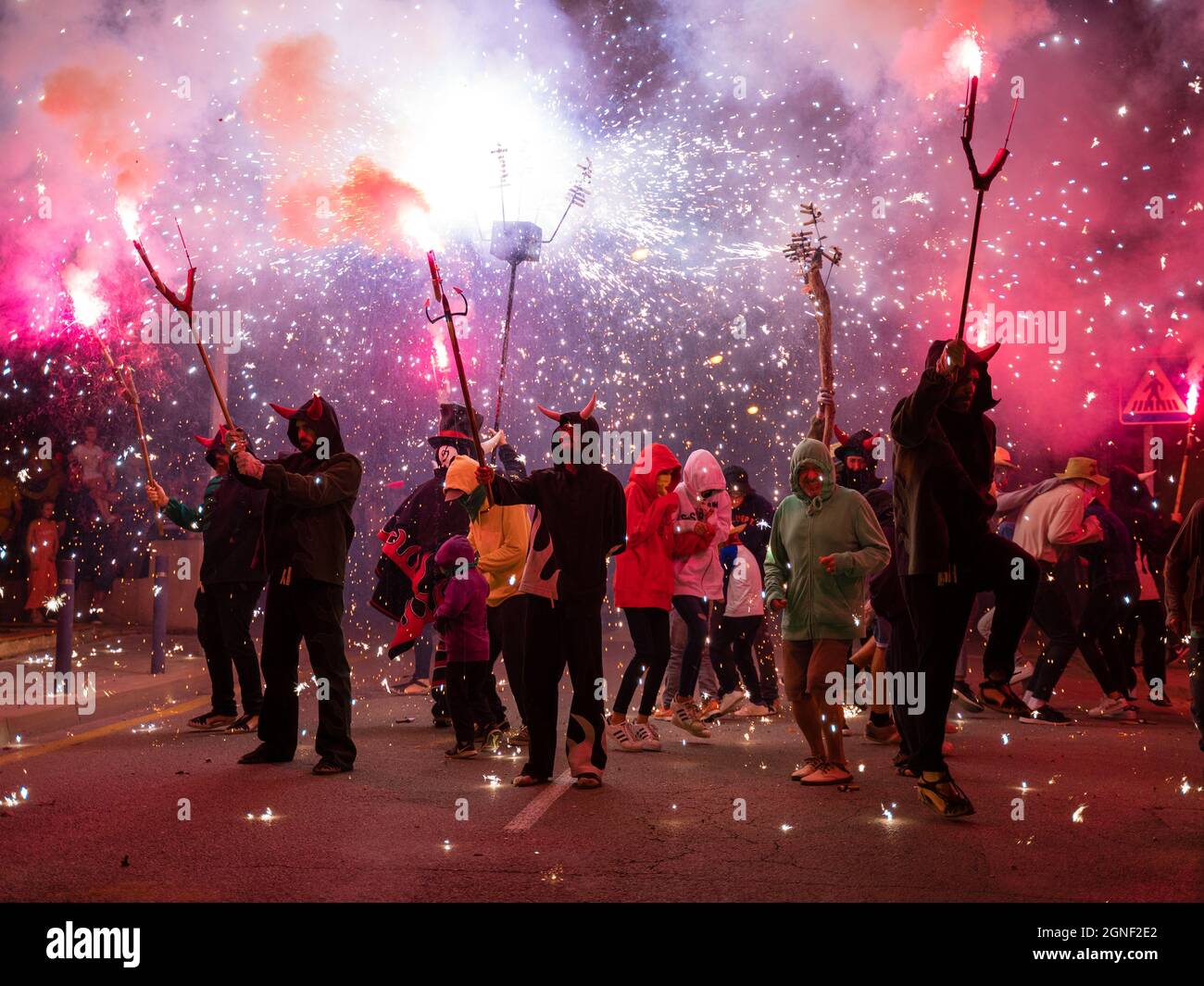 Fire Festival correfoc de los diablos de la garriga in l'ametlla del valles mit Teilnehmern gehen die Straße Pyrotechnik violett rot Stockfoto