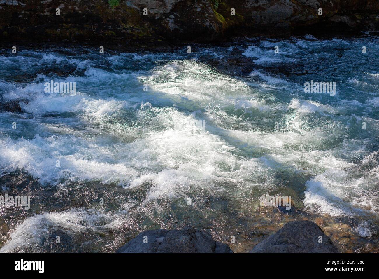 Ein schnell fließender breiter und voll fließender Gebirgsfluss. Stockfoto