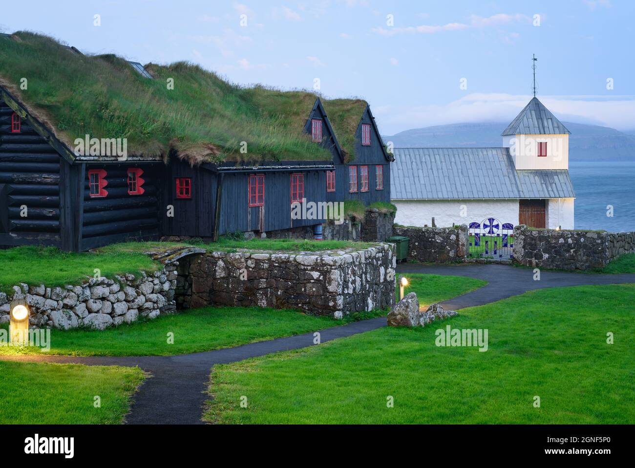 Altes Blockhaus von Kirkjuboargardur mit Rasendach in Kirkjubour Dorf auf Streymoy, Färöer Inseln Stockfoto